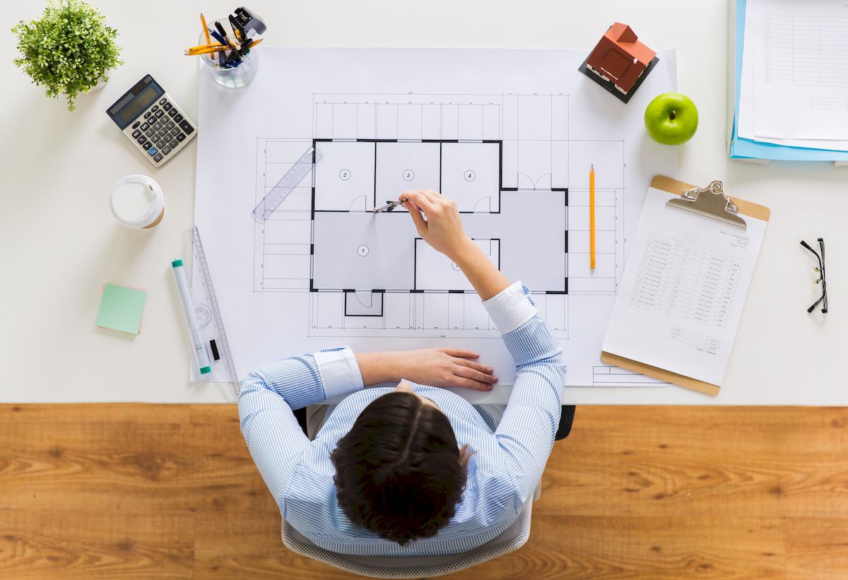 Architekt domów siedzi i pracuje nad projektem